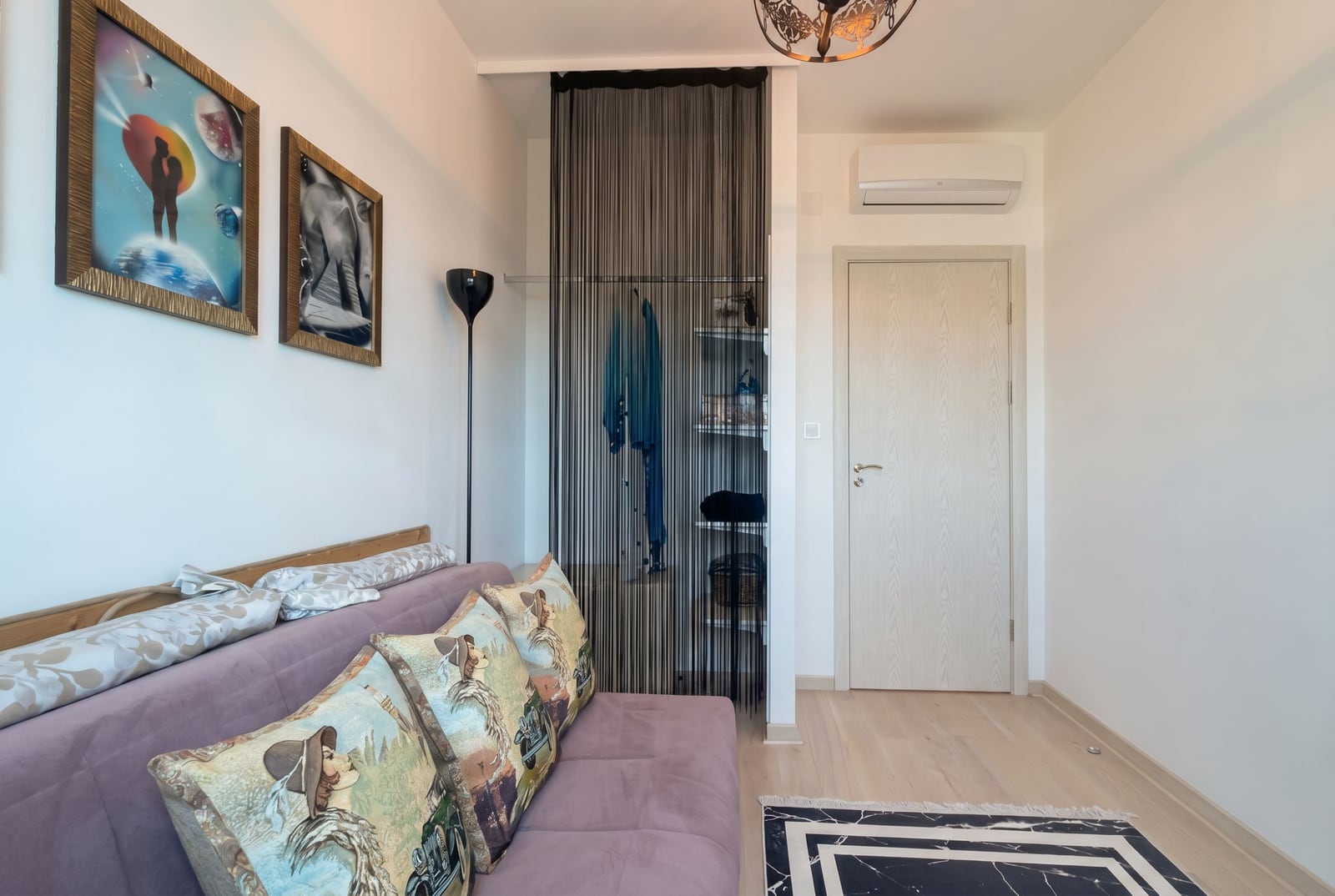 Living room with sofa and walk-in closet in an apartment in Bečići, Montenegro: modern interior with air conditioning and decor.