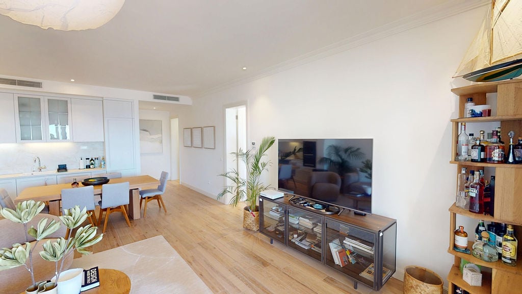 Modern living room with kitchen in an apartment, Luštica, Montenegro: bright interior, wooden floor, and stylish furniture.