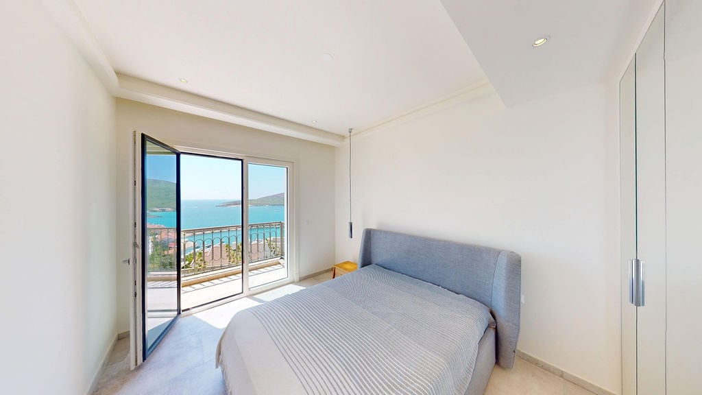Bedroom with a double bed and panoramic sea view in a residential complex, Luštica, Montenegro.
