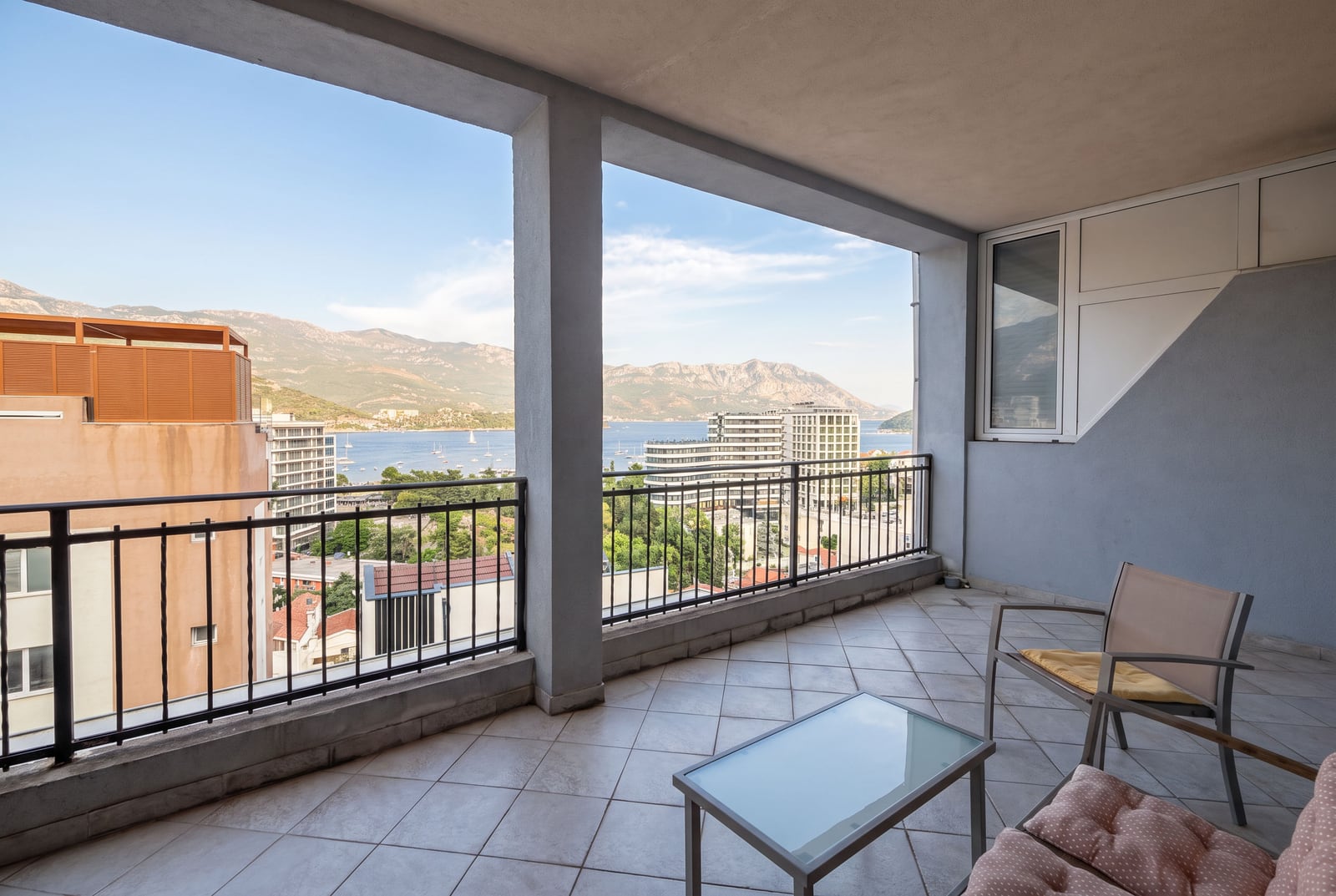 Spacious terrace with furniture and panoramic sea and mountain views in an apartment in Budva, Montenegro