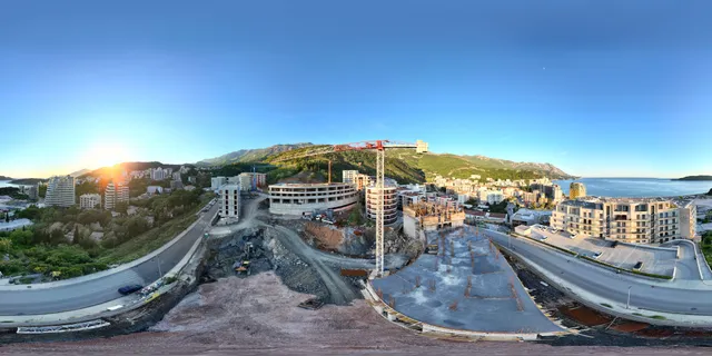 Panoramic view of a residential complex construction site in Bečići, Montenegro, overlooking the mountains and the Adriatic coast.